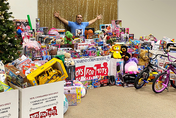 Doctor Alkhoury with room full of donations for Toys for Tots